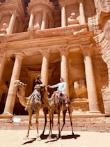 man riding horse in front of brown concrete building during daytime