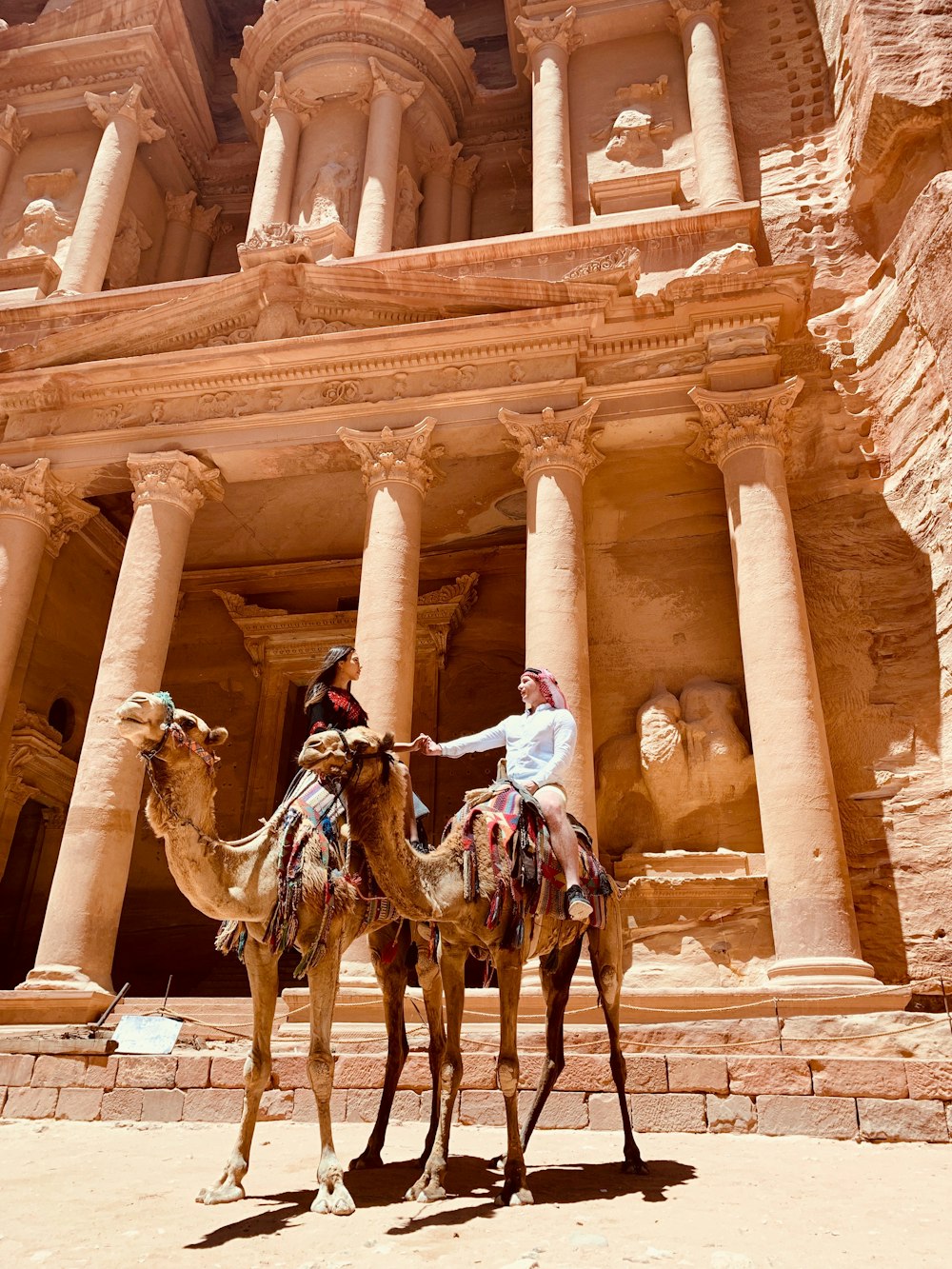 man riding horse in front of brown concrete building during daytime