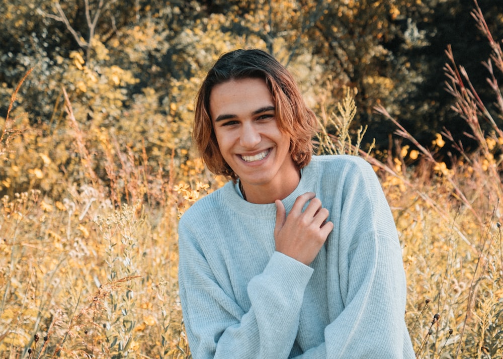 woman in gray sweater standing on brown grass field during daytime