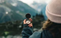 person holding black round container