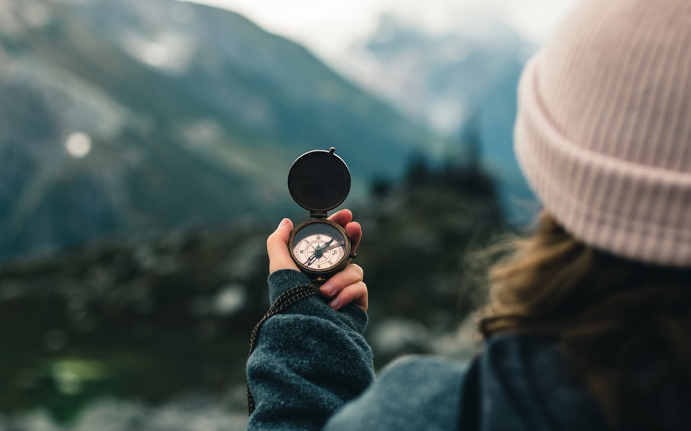 person holding black round container