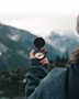 person holding black round container
