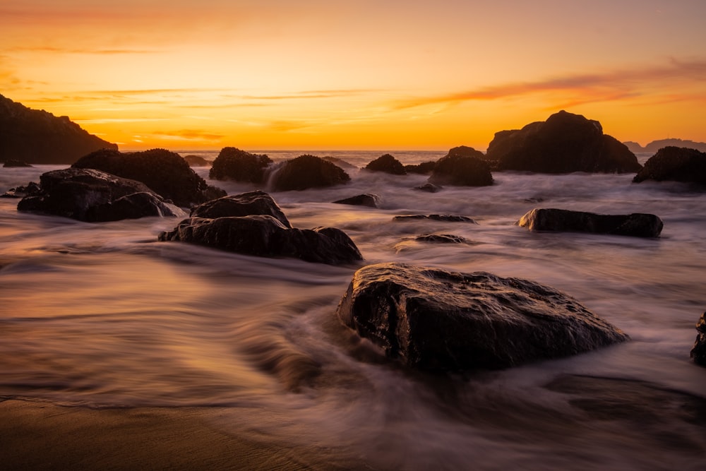 Les vagues de l’océan s’écrasent sur les rochers au coucher du soleil
