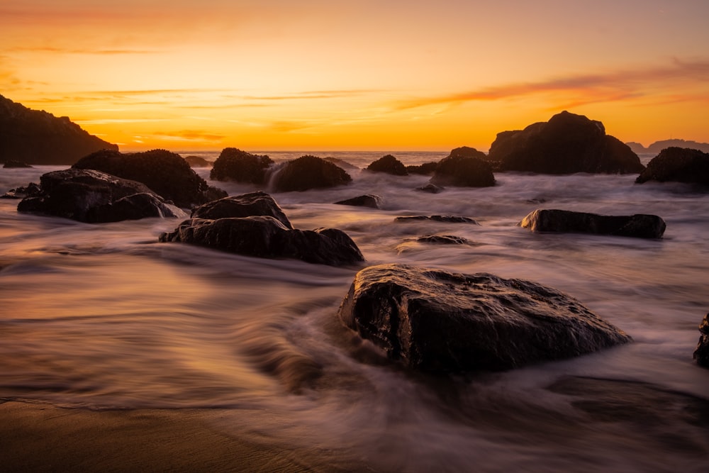 ocean waves crashing on rocks during sunset