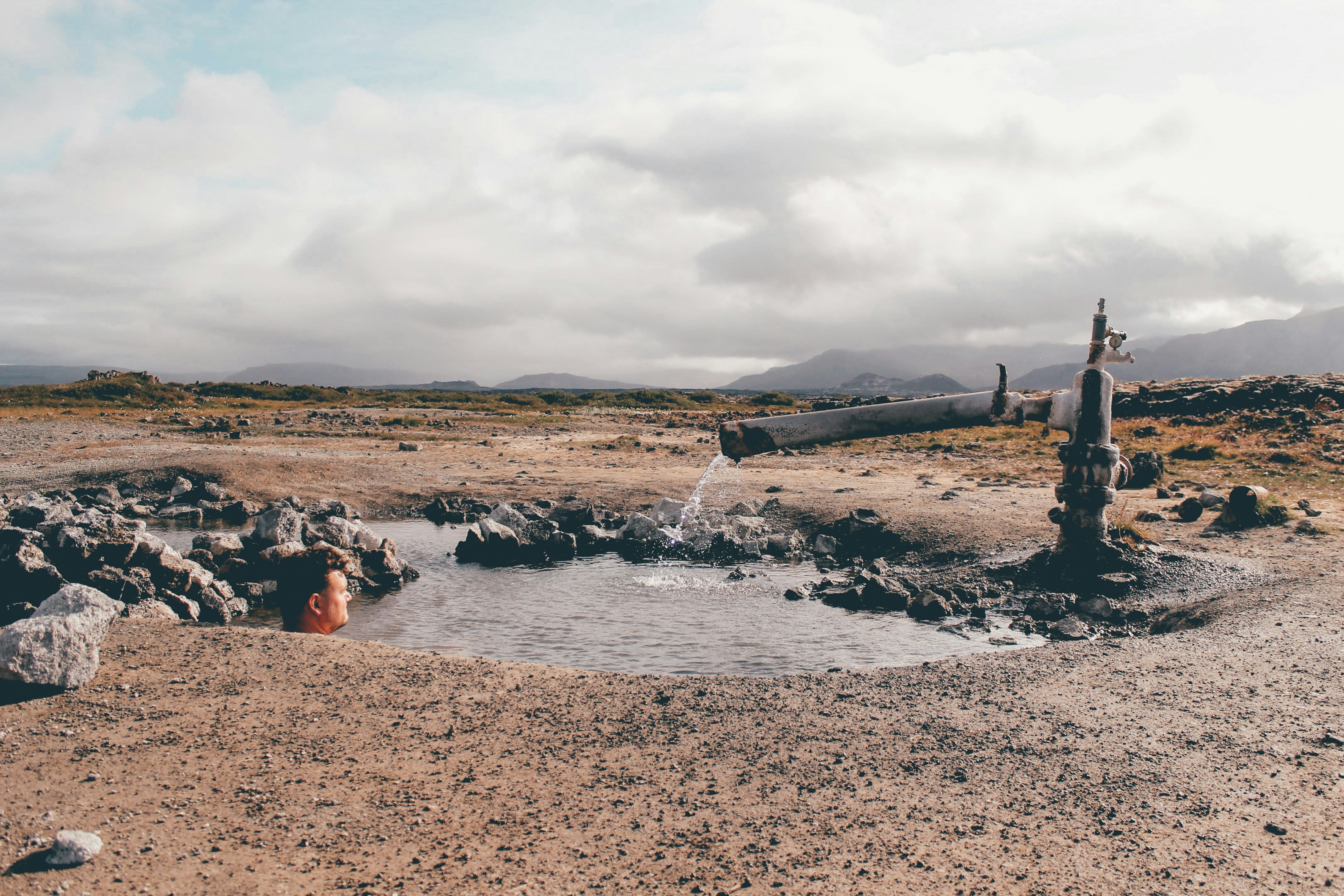 people sitting on brown sand near body of water during daytime