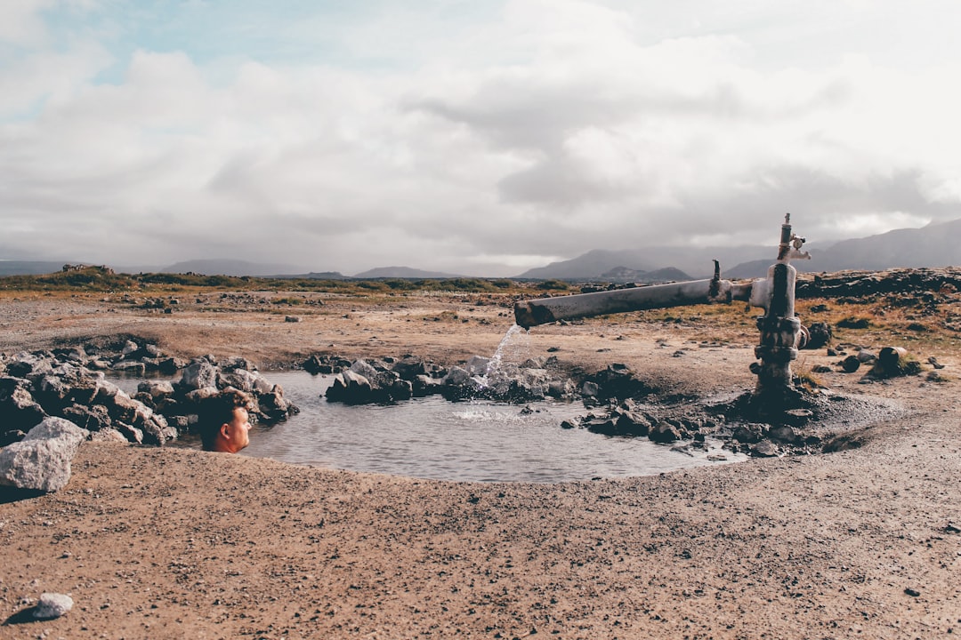 people sitting on brown sand near body of water during daytime