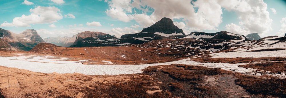 brown and white mountains under white clouds and blue sky during daytime