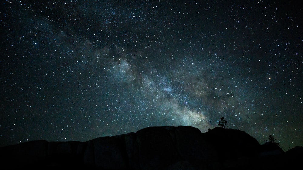 silhouette of mountain under starry night