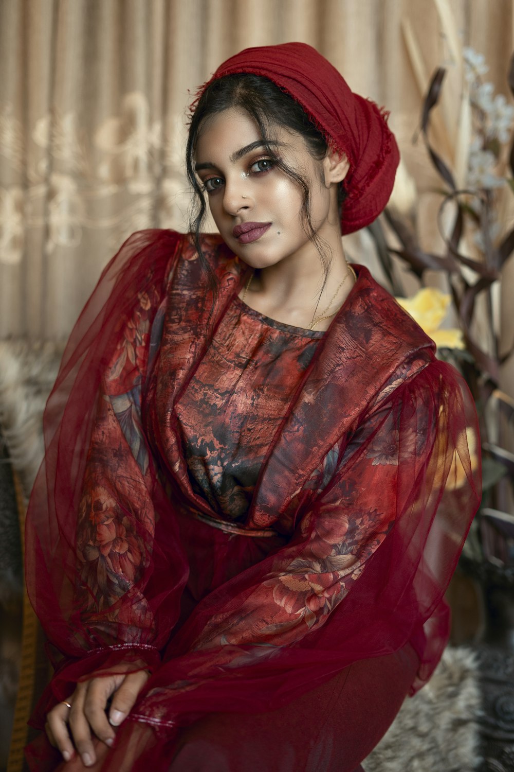 Femme en robe fleurie rouge et blanche portant un chapeau rouge