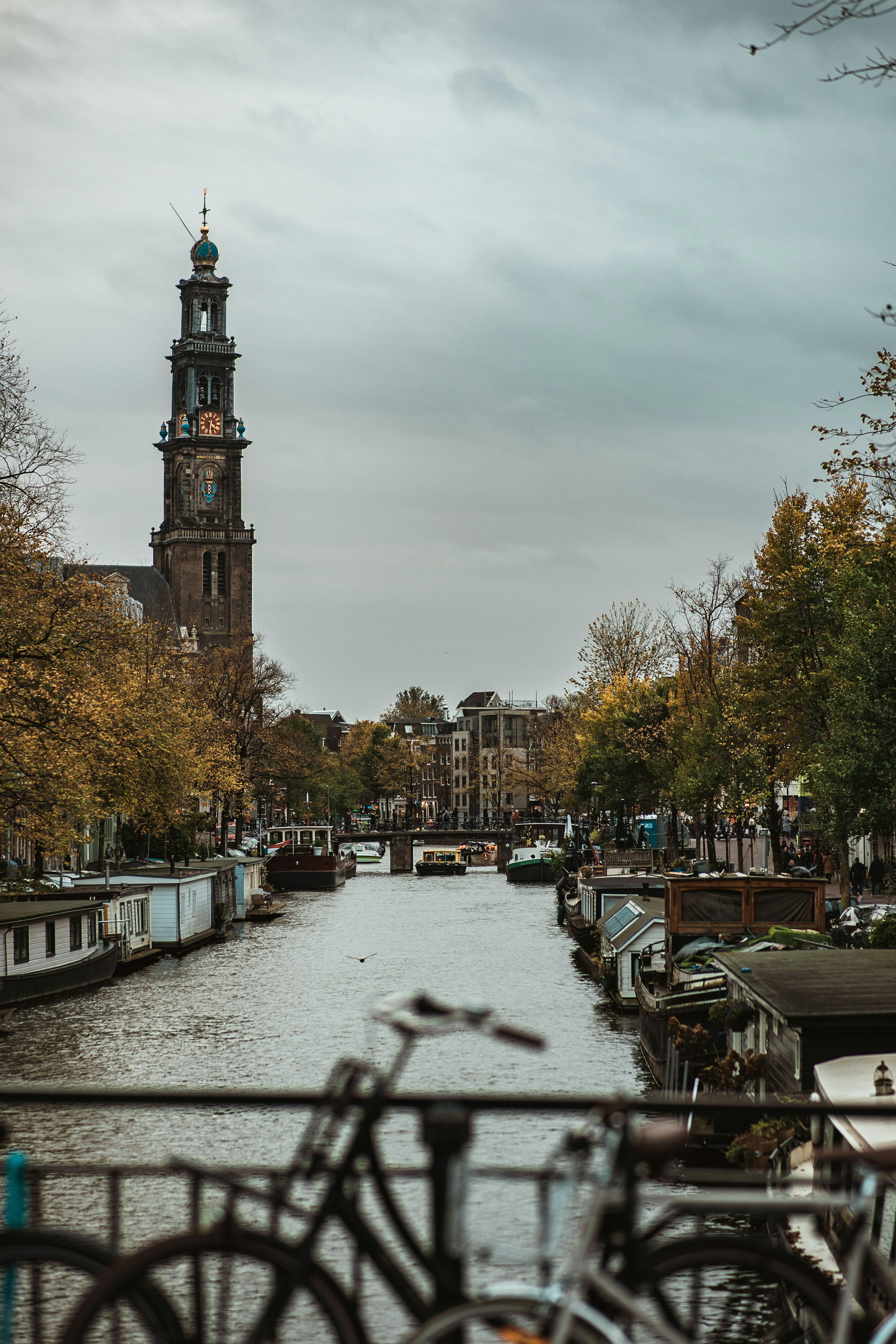 昼間、茶色のコンクリート塔の近くの歩道を歩く人々