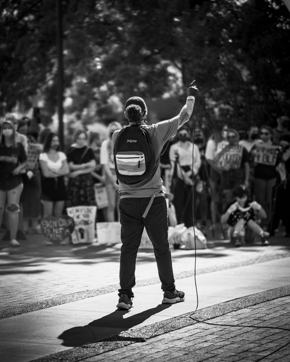 man in black t-shirt and black pants standing on street