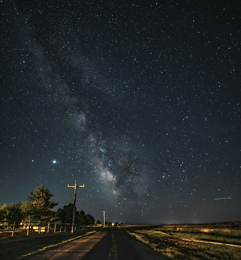 black asphalt road under starry night