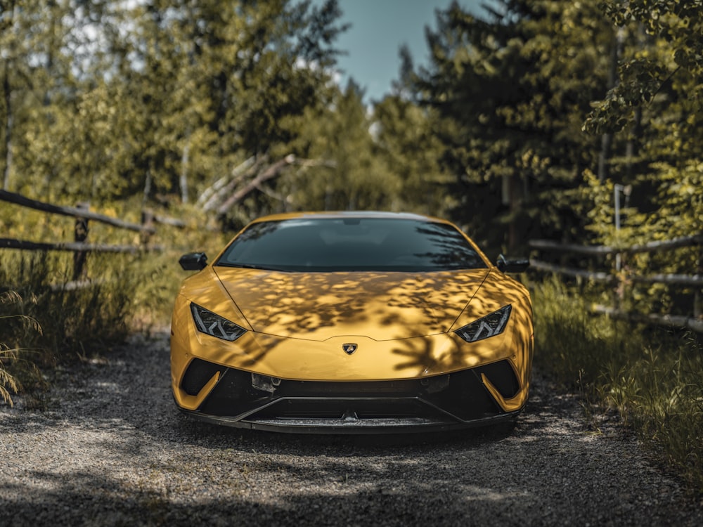 Gelber Lamborghini Aventador tagsüber auf grauer Asphaltstraße