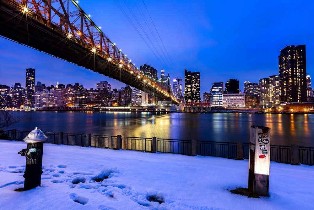 bridge over water near city buildings during night time