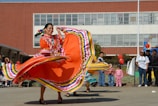 woman in red yellow and blue dress holding red and yellow textile