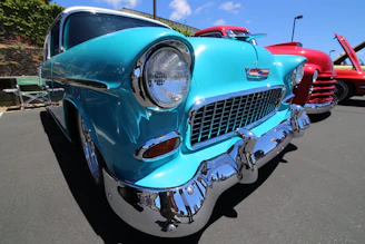 Close-up of a vintage car's polished chrome details under bright sunlight.