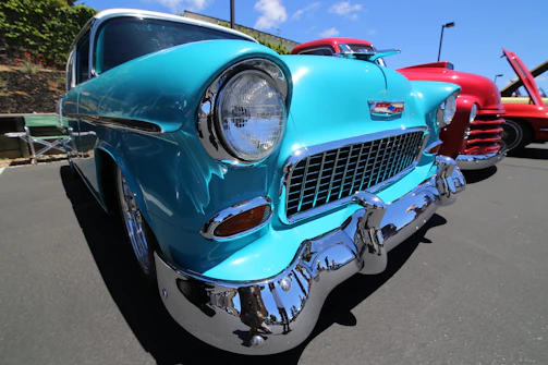Close-up of a vintage car's polished chrome details under bright sunlight.