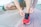 Close-up of a woman tying her running shoes on a city sidewalk.