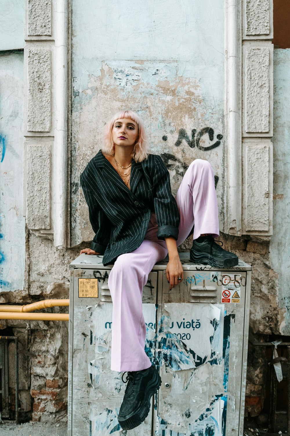 woman in black and gray hijab sitting on gray metal box