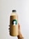 person holding clear glass bottle with white liquid