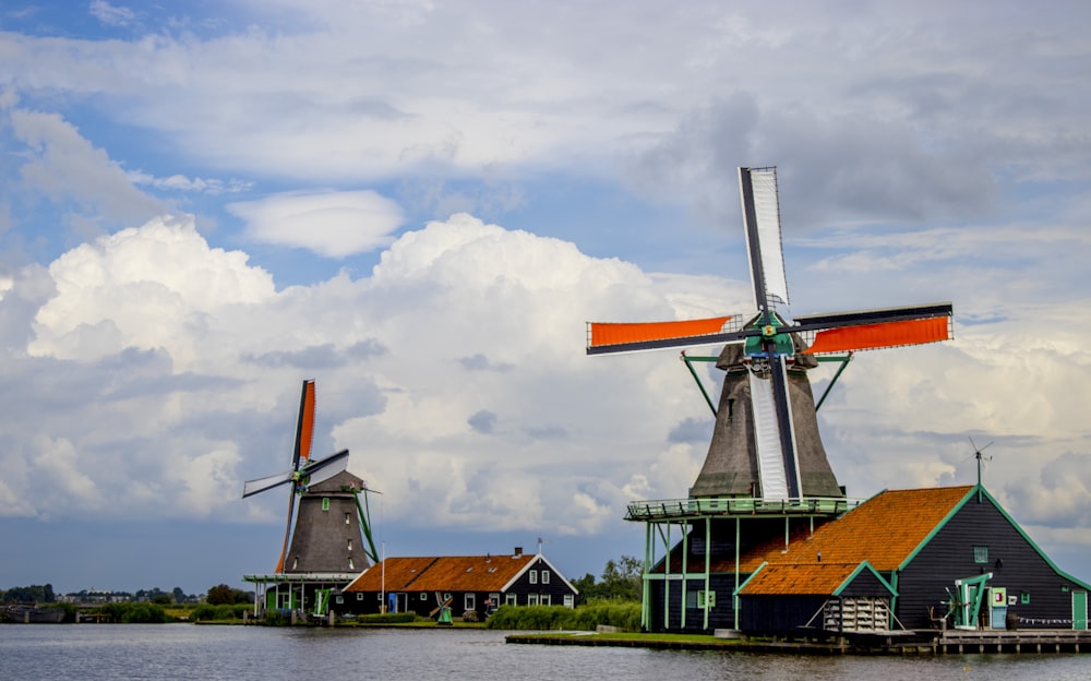 Moulin à vent vert et orange sous un ciel nuageux pendant la journée