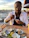 Smiling woman enjoying a fresh seafood dish at a cozy seaside bistro.