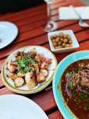 A rustic wooden table filled with traditional Spanish tapas dishes.
