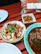 A rustic wooden table set with plates of grilled seafood and fresh herbs.
