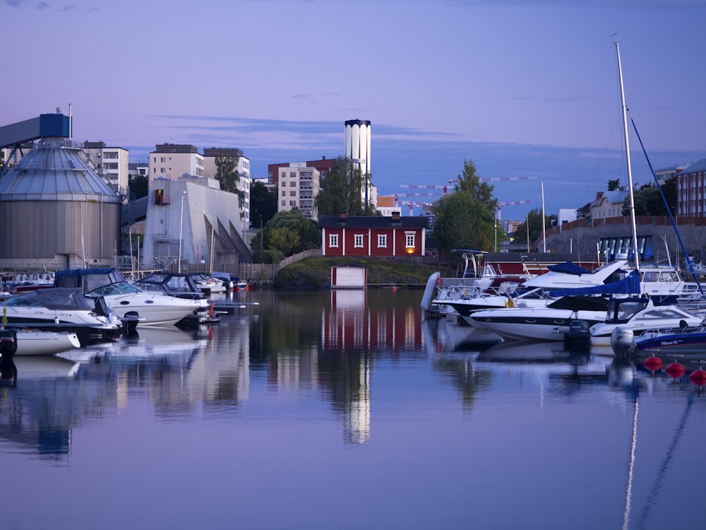 weißes und rotes Boot tagsüber auf dem Wasser in der Nähe des Gebäudes