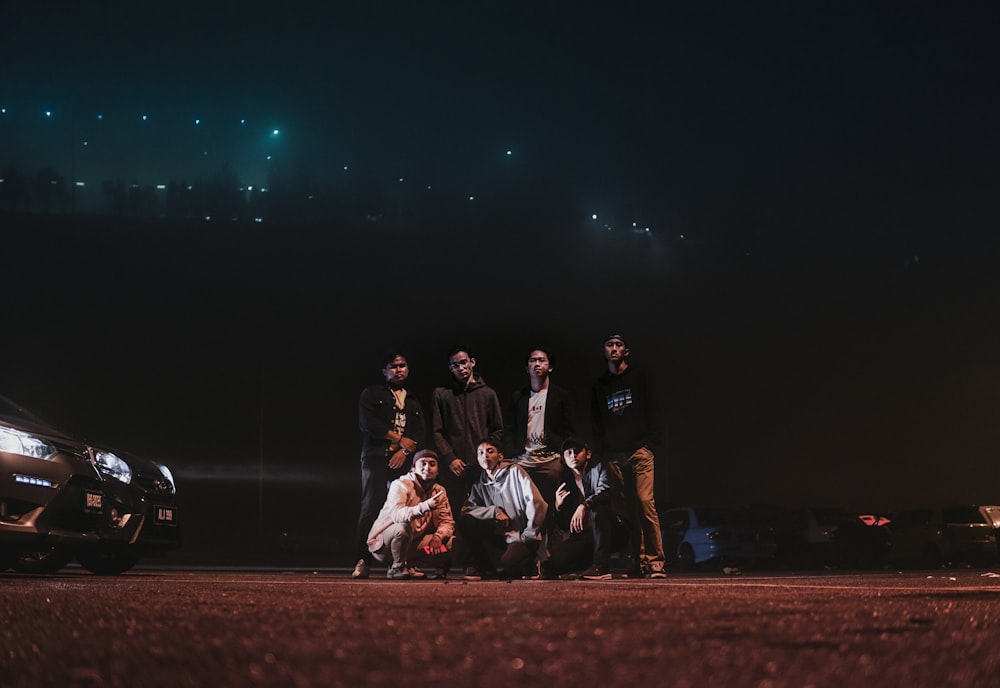 group of people sitting on brown field during night time