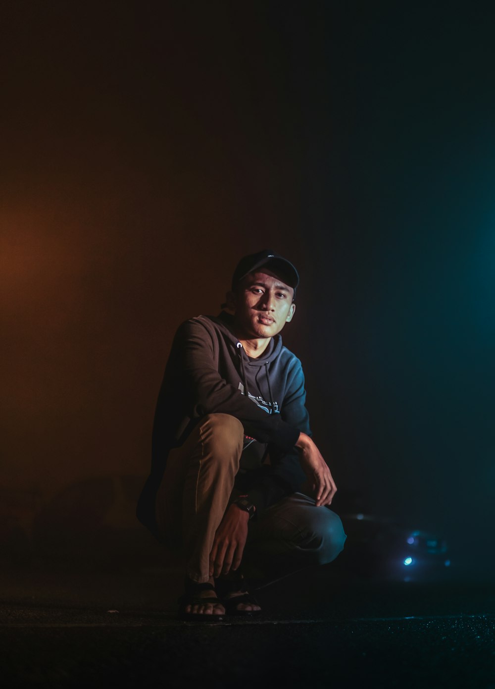 man in black jacket and black pants sitting on ground