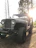 A close-up of a rugged buggy with a pristine custom composite body shining under the sunlight in a forest trail.