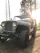 A close-up of a rugged buggy with a pristine custom composite body shining under the sunlight in a forest trail.