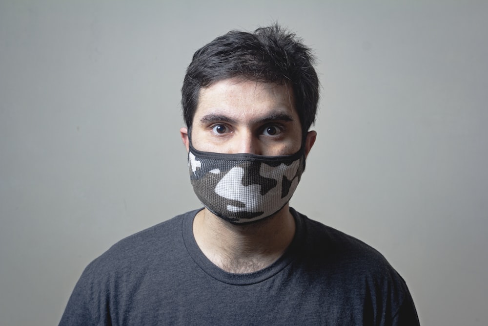 Mann in schwarzem Rundhalsshirt mit schwarz-weißer Maske