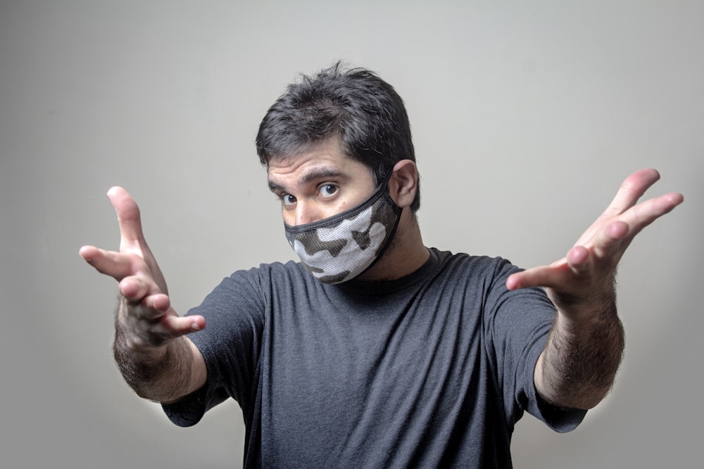 man in black crew neck t-shirt with white and black face mask