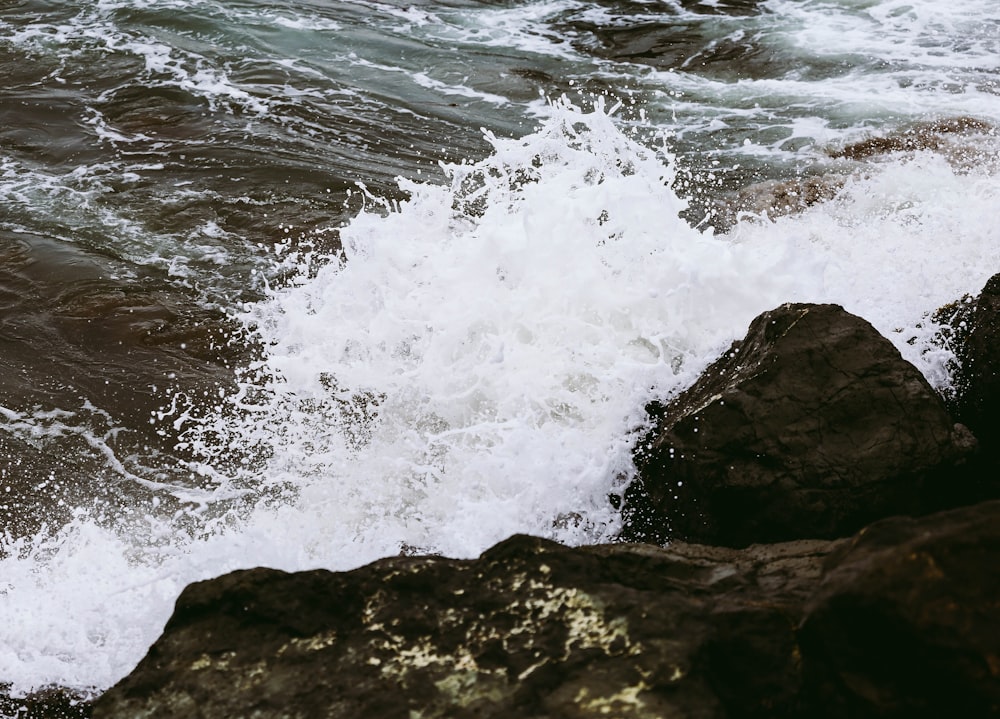 ocean waves crashing on brown rock