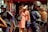 A group of police officers wearing protective gear, including helmets and body armor, stand near a woman holding a bag and shielding her eyes from the sun. Another person in a red tank top is visible nearby, holding a water bottle. The setting appears to be a busy street with a restaurant or shop in the background.