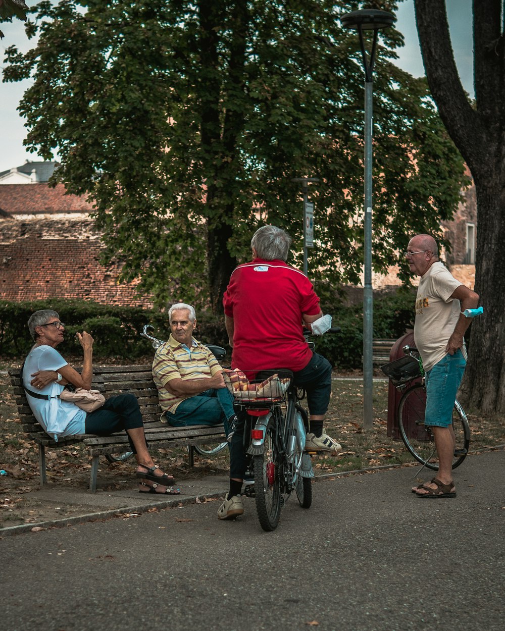 man in red shirt sitting on blue and black wheelchair beside woman in white shirt