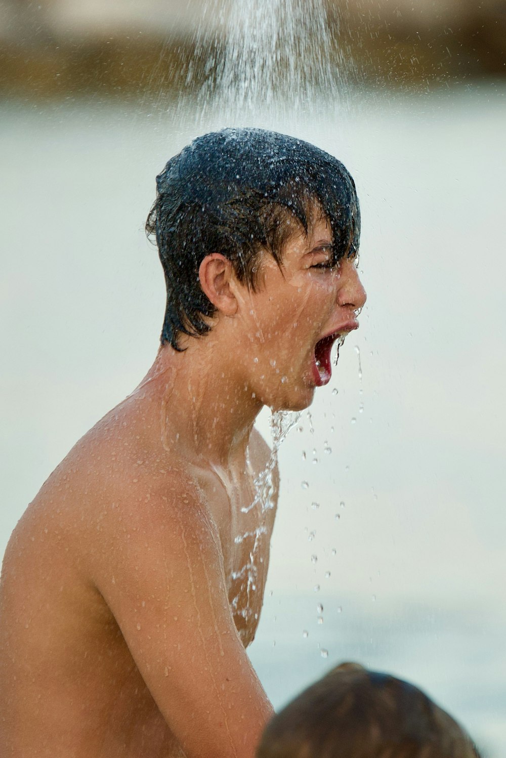 topless man with water droplets on his face