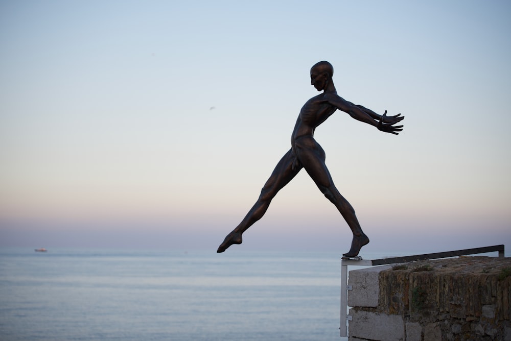 statue of man on top of concrete wall