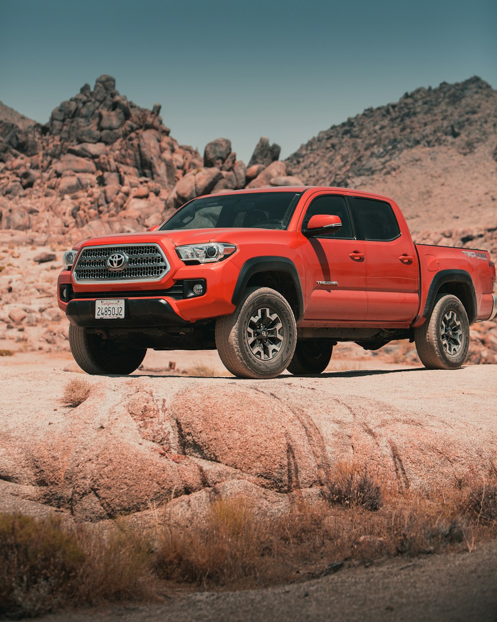 red chevrolet crew cab pickup truck on brown sand