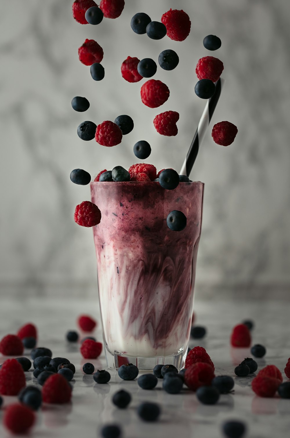 pink ice cream with red and blue berries on top