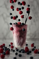 pink ice cream with red and blue berries on top