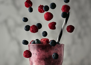 pink ice cream with red and blue berries on top