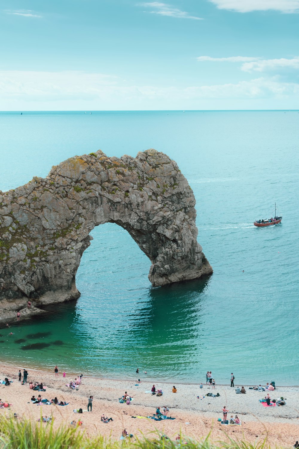 rock formation on body of water during daytime