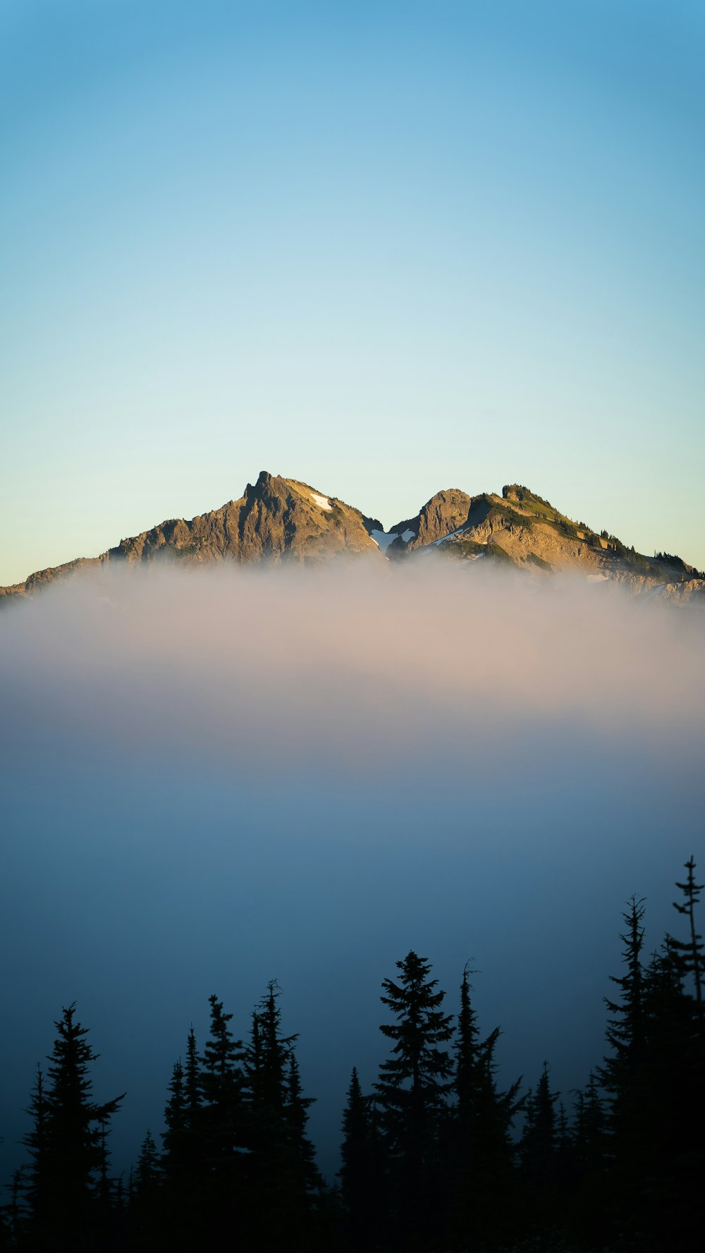 brown and white mountains under white clouds