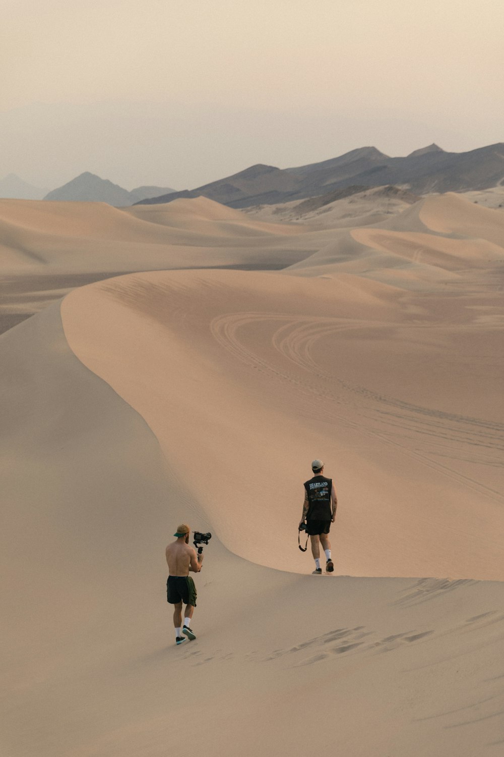 2 persone che camminano nel deserto durante il giorno