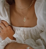 woman in white off shoulder dress wearing silver necklace