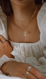 woman in white off shoulder dress wearing silver necklace