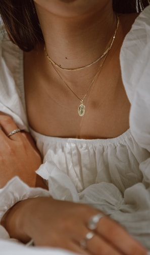 woman in white off shoulder dress wearing silver necklace